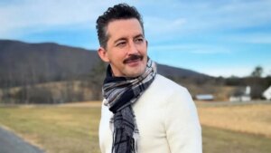 Джош Грізетті, актор серіалу «Дивовижна місіс Мейзел», у білому светрі на природі