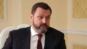 Андрій Деркач у чорному костюмі з бородою та краваткою