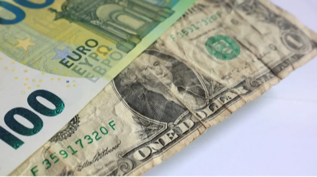 Банкноти 100 євро та 100 доларів на білому тлі