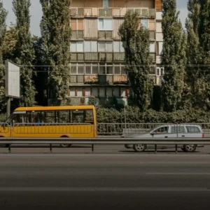 Жёлтая маршрутка Киева на дороге возле панельного дома