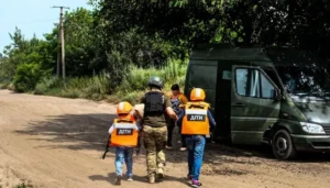 Евакуація дітей у жилетах ДІТИ до автомобіля в зоні бойових дій
