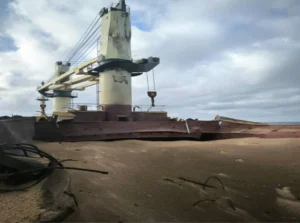 Пошкоджений зерновоз після ракетної атаки РФ трьома крилатими ракетами в Чорному морі на піщаному березі, наслідки удару по цивільному судну.