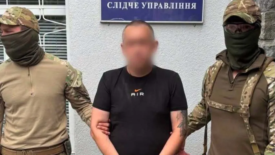 Станислав Лучанов под стражей между двумя бойцами следственного управления
