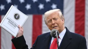 Дональд Трамп тримає звіт про торговельні барєри на тлі прапора США