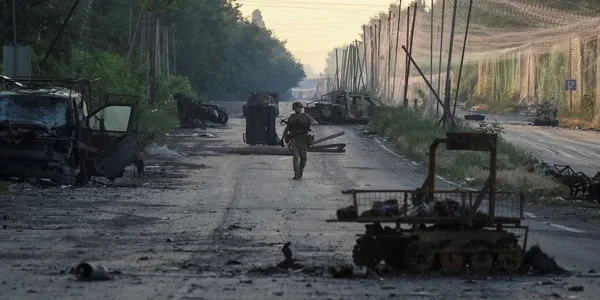 Український військовий на зруйнованій дорозі в Костянтинівці серед знищеної техніки РФ