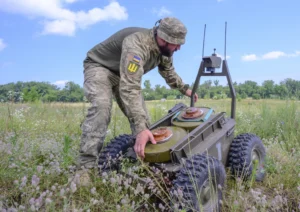 Военный ВСУ настраивает наземный боевой дрон на Кинбурнской косе
