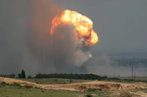 Потужний вогняний вибух з димом над пагорбами та лініями електропередач