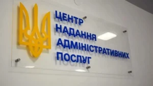 Скляна вивіска з жовтим тризубом і написом центру адміністративних послуг