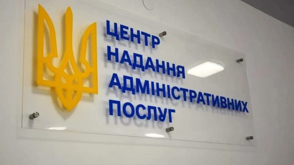 Скляна вивіска з жовтим тризубом і написом центру адміністративних послуг